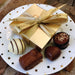 Beautiful Leonidas gold gift box with a bow on a festive plate with four assorted chocolates