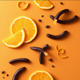 slices of orange lay beside chocolate-dipped arcs of candied orange rind on an orange background